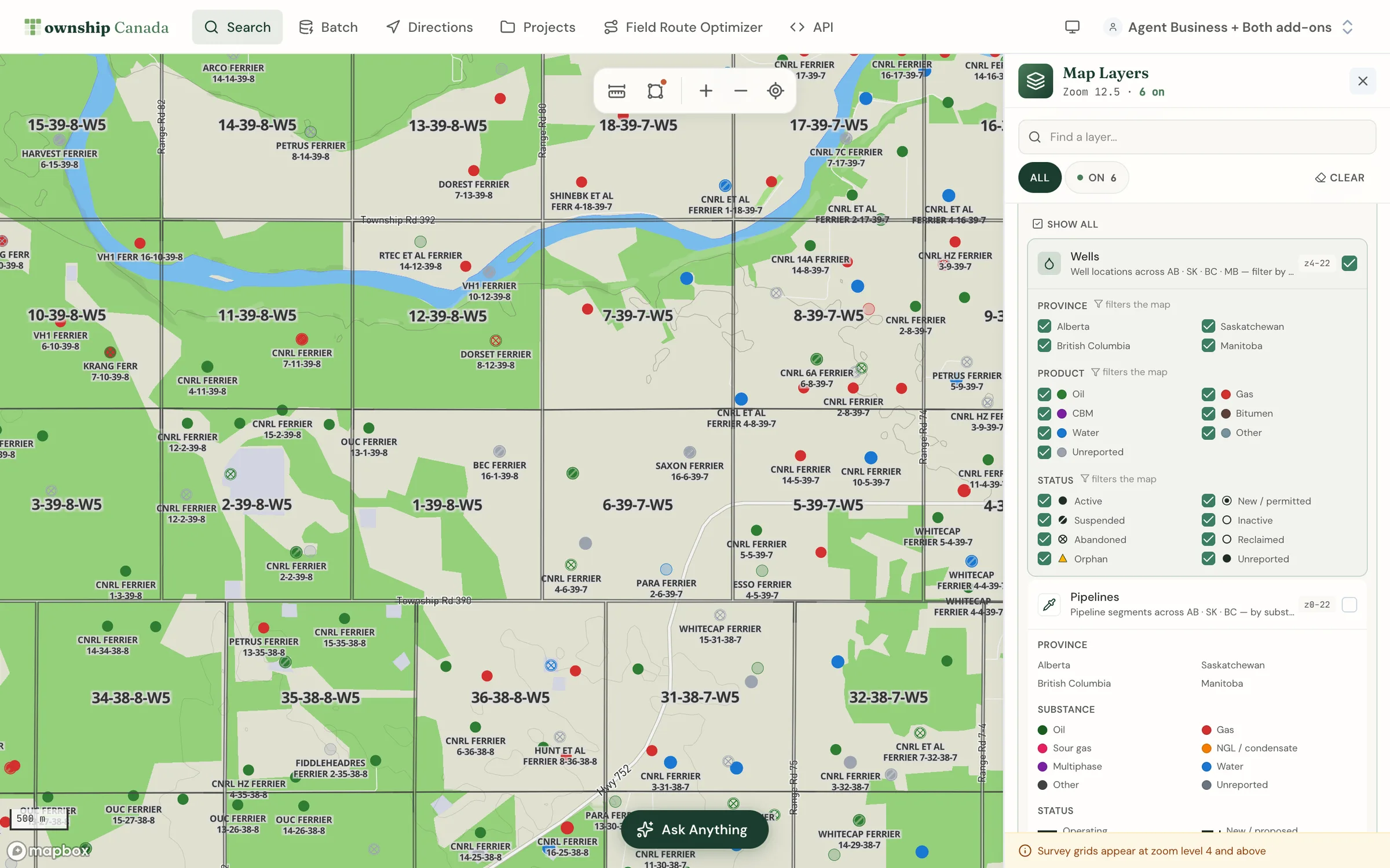 The Wells layer near Rocky Mountain House, Alberta, with each well styled by product and licence status and the status legend in the Layers panel